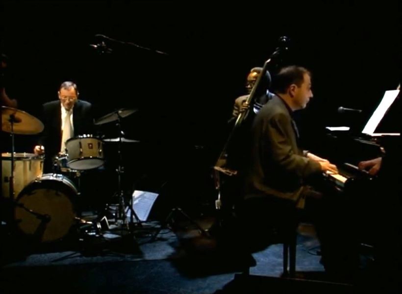 Lolo Bellonzi (dm) en trio avec Wayne Dockery (b) et Olivier Hutman (p), documentaire Tambour battant (Gérard Teillay, 2004), image extraite de YouTube